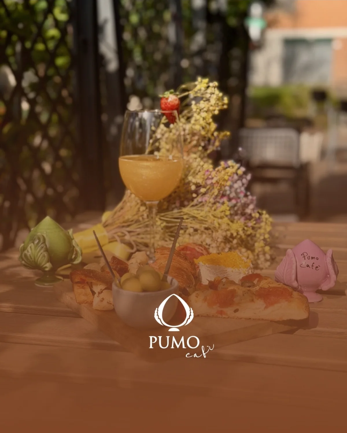 Tagliere dell'aperitivo con cocktail e pumi in ceramica sul tavolo del locale